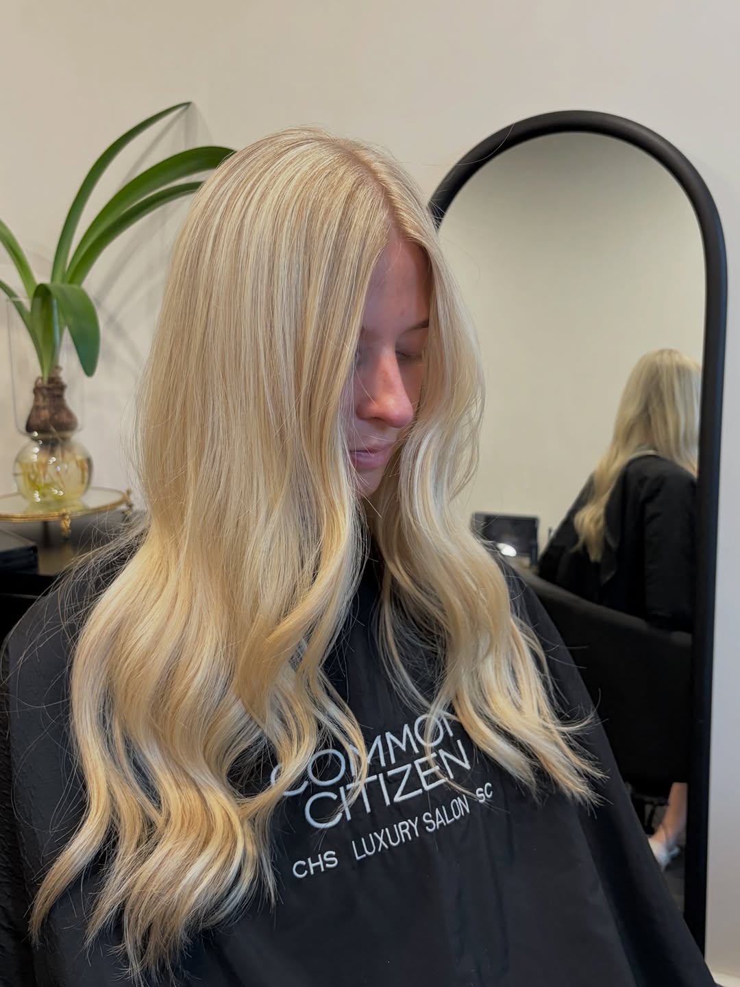 A Common Citizen client with finished long blonde balayage waves — editorial portrait inside the salon.